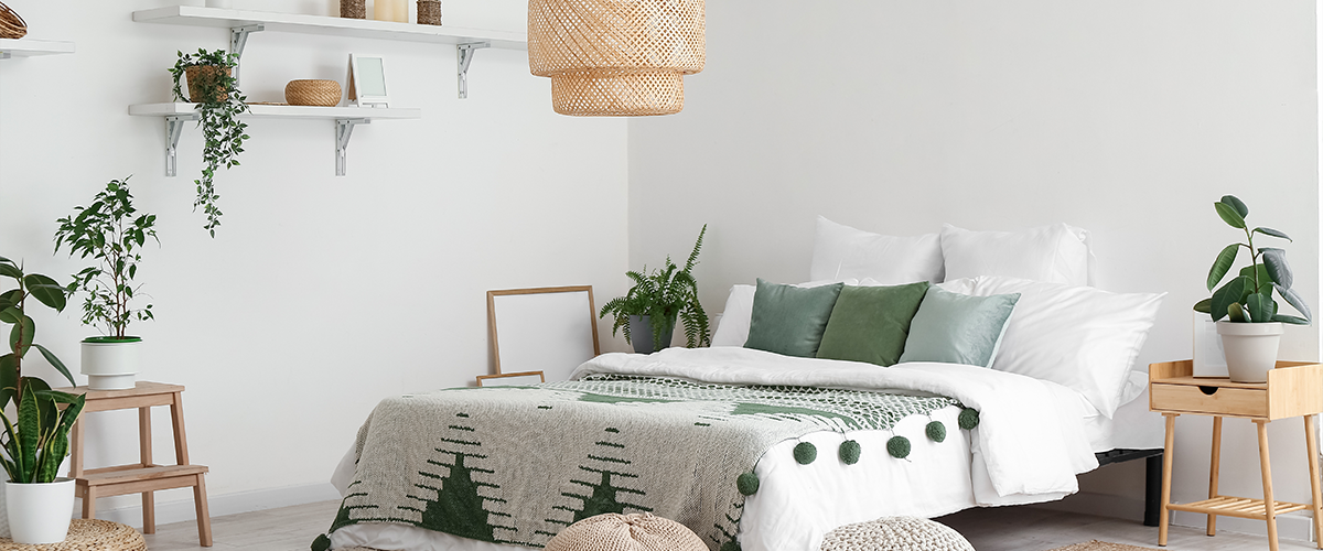 A minimalist bedroom with natural decor, featuring green accents, potted plants, and woven accessories for a cozy, organic feel.