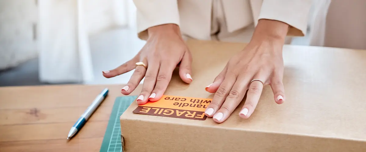 Hand of person labeling a box.