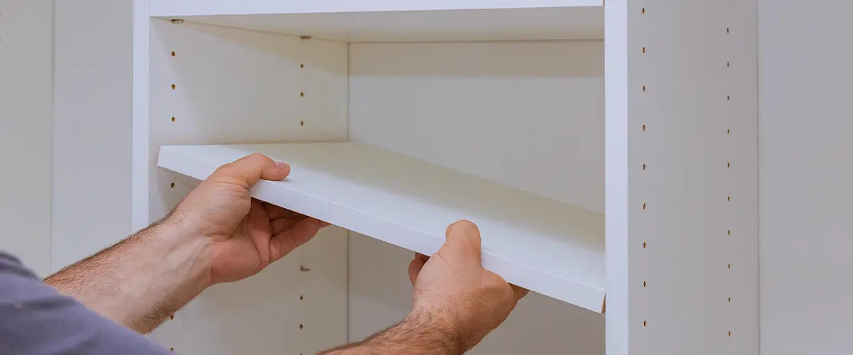 Worker sets the shelf for closet installations