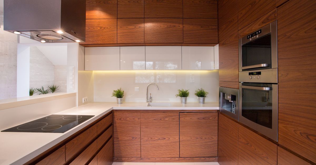 A sleek modern kitchen with rich wood cabinetry, glossy white upper cabinets, under-cabinet lighting, and built-in stainless steel appliances for a contemporary aesthetic.