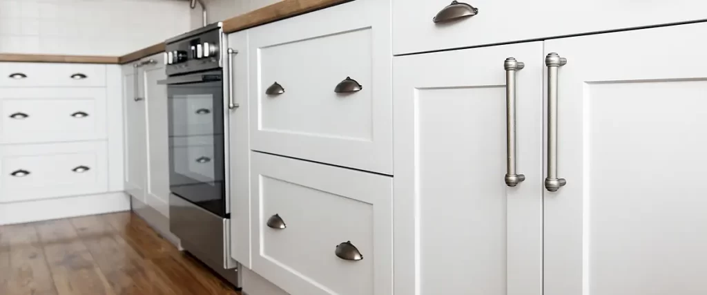 Modern white kitchen cabinets with wood countertops, stainless steel appliances, and classic shaker-style design.