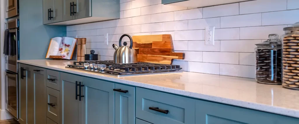 Stylish kitchen with green shaker cabinets, white subway tile backsplash, and modern black hardware for a contemporary look.