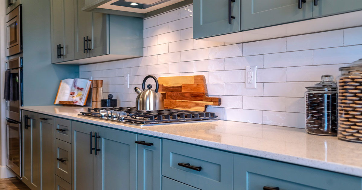 Stylish kitchen with green shaker cabinets, white subway tile backsplash, and modern black hardware for a contemporary look.